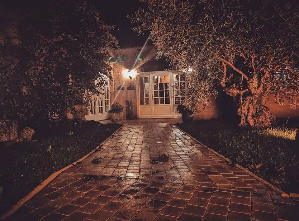 L'allée pavée qui mène au restaurant, éclairée la nuit