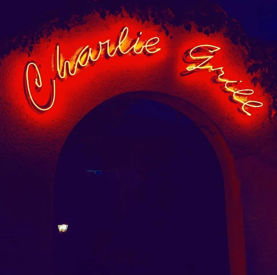 L'enseigne au néon rouge Charlie Grill sous une arche