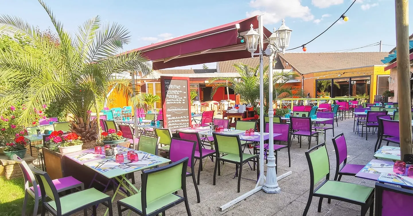 La terrasse fleurie et ses chaises colorées autour de la piscine